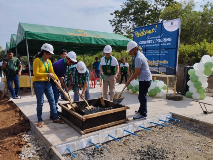 Lumbia Punong Barangay Alex Torralba (center) leads the April 5 concrete pouring rites for the La Aldea del Rio access road at Lower KIam-is, Lumbia, Cagayan de Oro City . He is assisted by Mr & Mrs Alvin Ryan & Ma. Theresa Lee of El Elyon Realty & Development Corp (left), PDO VP & GM Chrysler Acebu & ILMI Project Manager Roger Aleria (RMB).